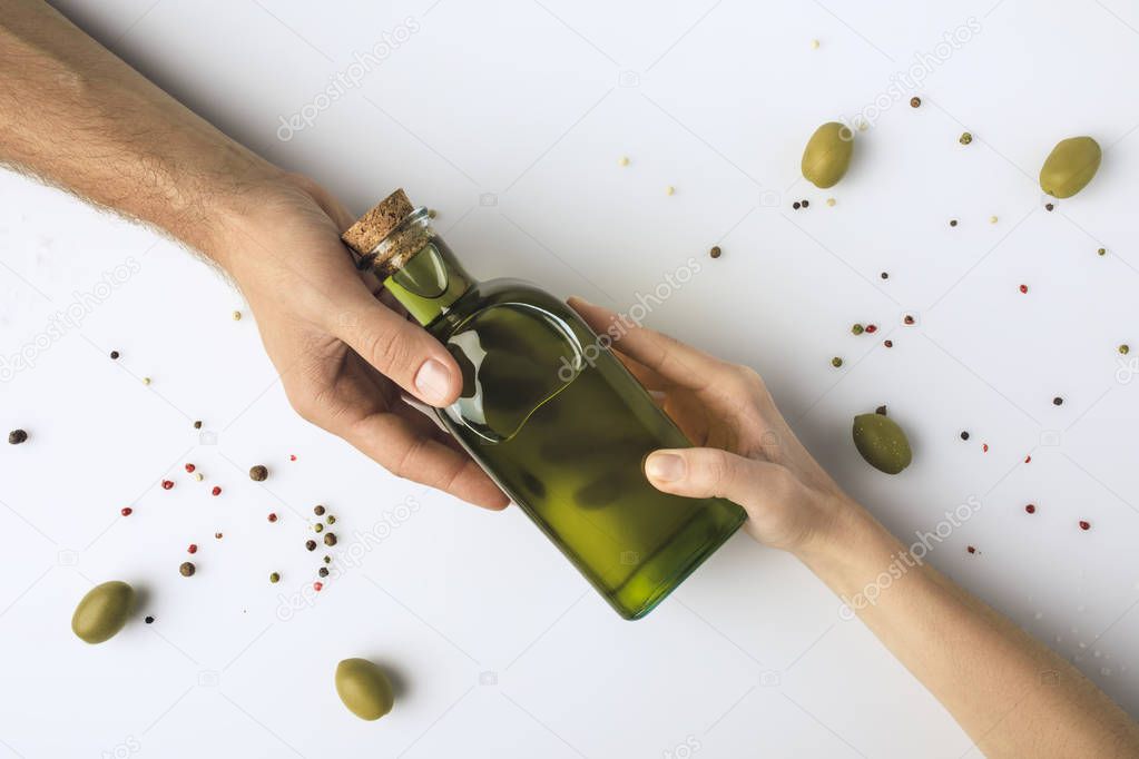 man and woman holding bottle of oil