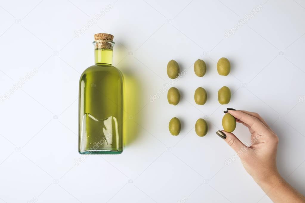 oil bottle and woman holding olive
