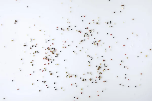 Spridda peppar på vit yta — Stockfoto