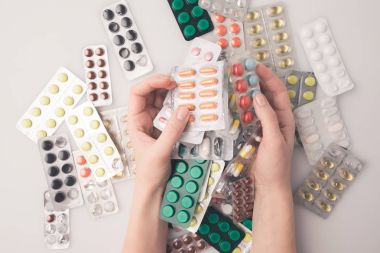 blister paketleri yığını tutan kadın
