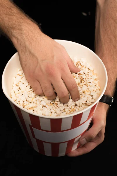 Man taking popcorn out of bucket — Stock Photo, Image