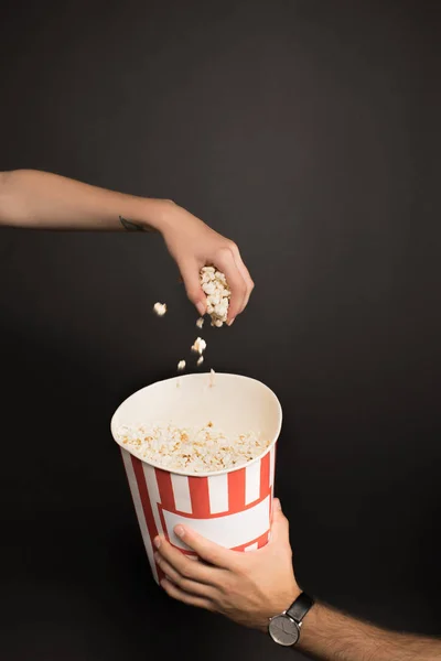 Woman taking popcorn out of bucket — Free Stock Photo