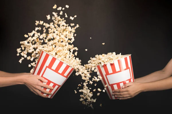 People spilling out popcorn from buckets — Stock Photo, Image