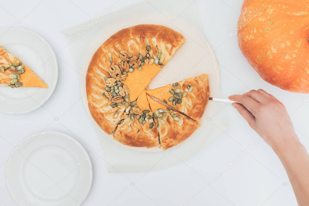woman taking slice of pumkin pie