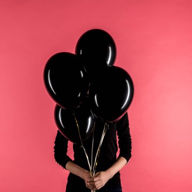woman holding black balloons