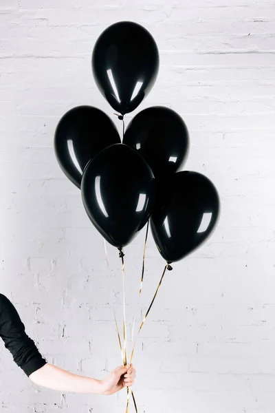 Persona in possesso di palloncini neri — Foto Stock