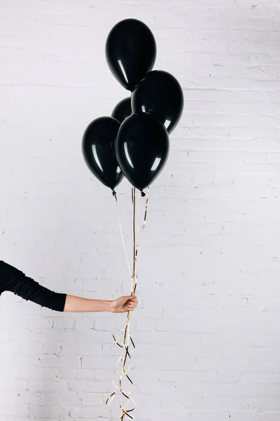 Mujer sosteniendo globos negros — Foto de Stock