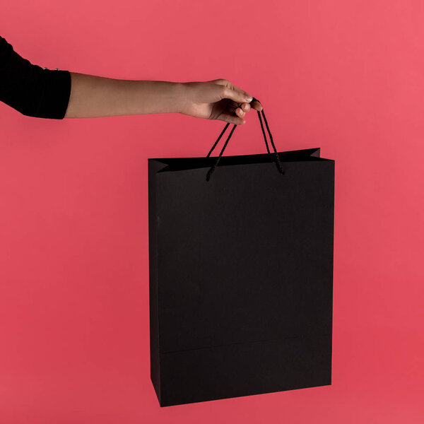 woman holding black shopping bag