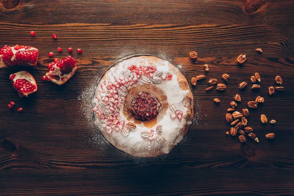 Christmas cake with icing, nuts and pomegranate — Stock Photo, Image