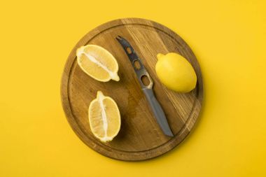 lemons and knife on wooden board clipart