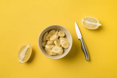 Plate with cut bananas and knife clipart