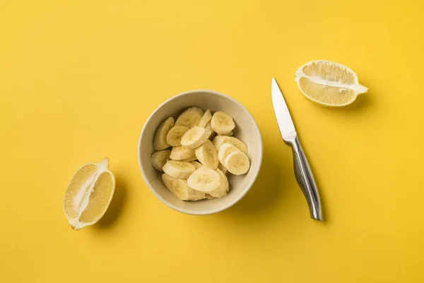 Тарелка с разрезанными бананами и ножом — стоковое фото