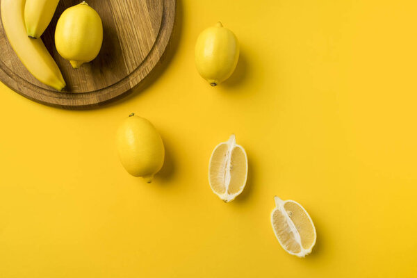 lemons and bananas with wooden board