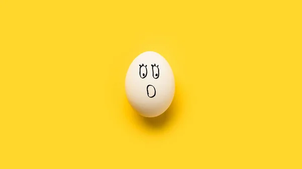 Bemaltes Hühnerei mit schockiertem Emoji — Stockfoto