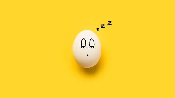 Ovo de galinha pintado com emoji adormecido — Fotografia de Stock