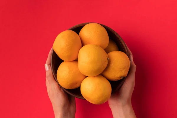 Tangan memegang mangkuk dengan tangerine — Stok Foto