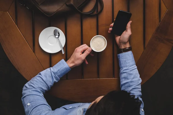 Άνθρωπος με καφέ χρησιμοποιώντας smartphone — Φωτογραφία Αρχείου