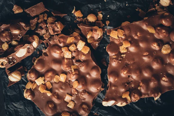 Milk chocolate with nuts and nougat pieces — Stock Photo, Image