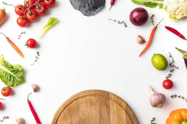 Tábua de madeira e legumes não transformados — Fotografia de Stock