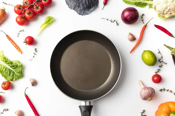 Pan among uncooked vegetables — Stock Photo, Image