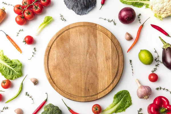 Wooden board among vegetables — Stock Photo, Image