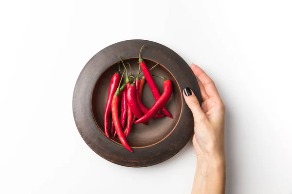 Woman holding plate with chili peppers — Stock Photo, Image