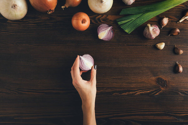 женщина держит половину лука
 