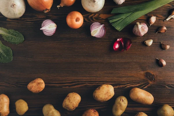 Batatas com cebola e alho na mesa — Fotografia de Stock