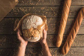 bochník chleba v ruce a bagety