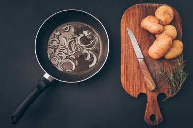 gri masada frying pan ile soğan ve patates ile ahşap tahta Üstten Görünüm
