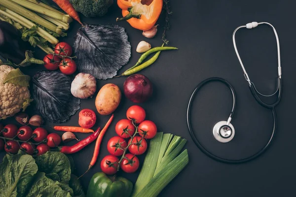 成熟蔬菜和听诊器的顶部视图在灰色桌 — 图库照片