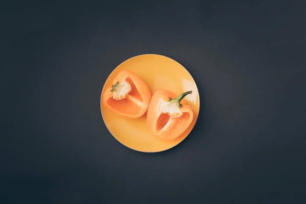 Top view of two halves of yellow bell pepper on yellow plate on gray — Stock Image Top View Two Halves Yellow Bell Pepper Yellow Plate Gray Stock Image