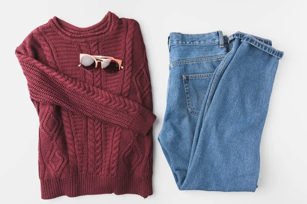 Gebreide trui, spijkerbroek en zonnebril — Stockfoto
