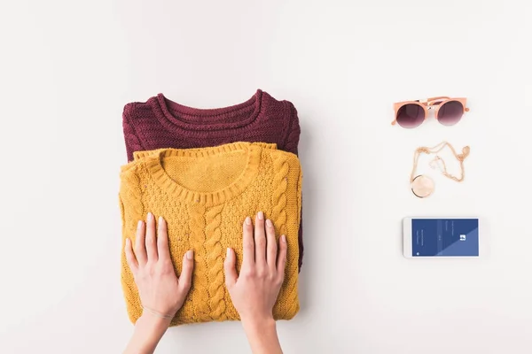 Suéteres y smartphone con aparato de facebook — Foto de Stock