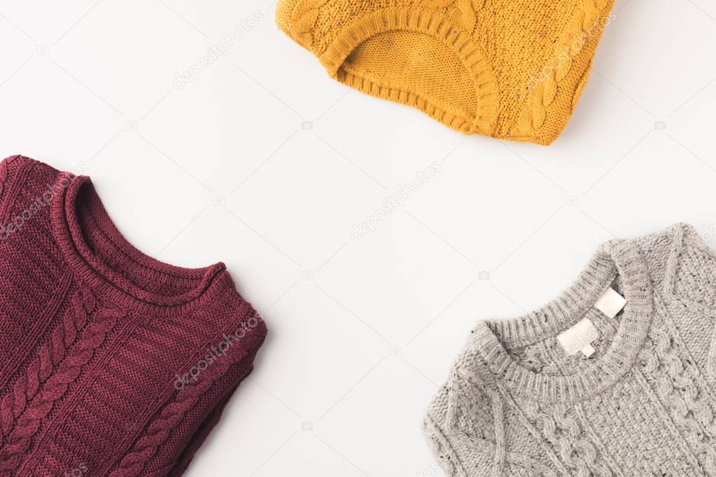 grey, burgundy and yellow sweaters