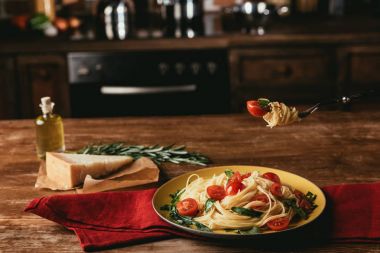 lezzetli İtalyan pasta plaka Parmesan ve biberiye ile tabloda roka ve domates ile