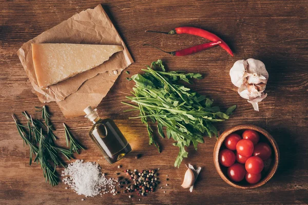 木製のテーブルにパルメザン チーズ オイルと新鮮な食材のトップ ビュー — ストック写真