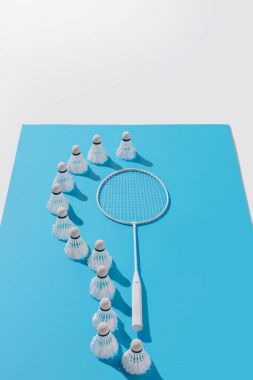 badminton raket ve shuttlecocks yüksek açı bakış beyaz izole mavi kağıt üzerinde