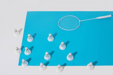 Mavi kağıt üzerinde beyaz badminton raket ve shuttlecocks yüksek açılı görünüş