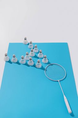Beyaz badminton raket ve shuttlecocks mavi kağıt kompozisyonu