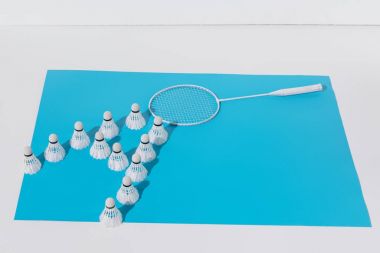 Beyaz badminton raket ve shuttlecocks mavi kağıt kompozisyonu