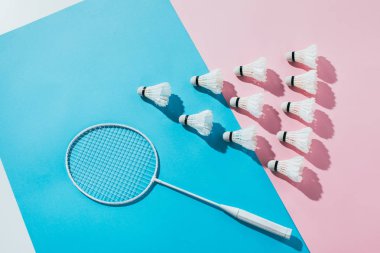 badminton raket ve shuttlecocks kompozisyonu üstten görünüm, mavi ve pembe kağıtlara