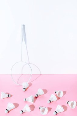 Beyaz badminton raket ve shuttlecocks duvar, pembe kağıt üzerinde
