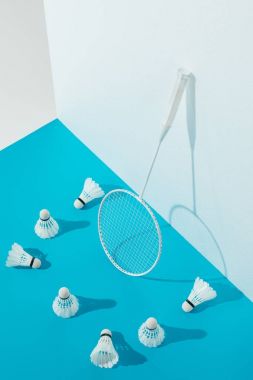 Badminton Raket ve shuttlecocks beyaz duvar, mavi kağıt üzerinde 