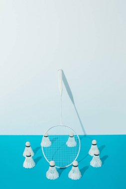 Badminton Raket ve shuttlecocks beyaz duvar yakınındaki mavi kağıt üzerinde 