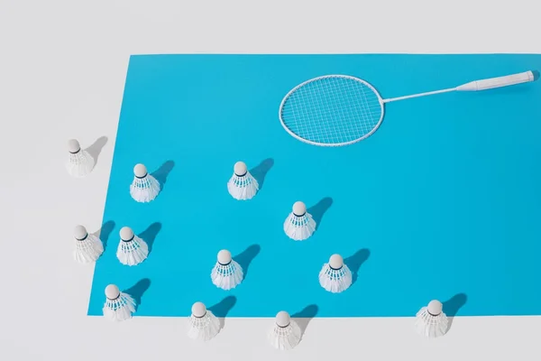 Mavi Kağıt Üzerinde Beyaz Badminton Raket Shuttlecocks Yüksek Açılı Görünüş — Stok fotoğraf