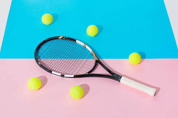 tennis racket and yellow balls on blue and pink papers