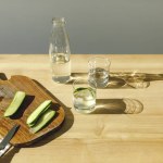 Cut cucumbers on wooden board and mineral water on wooden tabletop