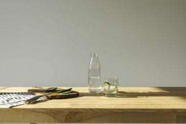 Salatalık kesme ve su ahşap masa üzerinde Detoks