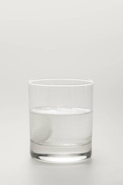 effervescent pill in glass of water isolated on white clipart